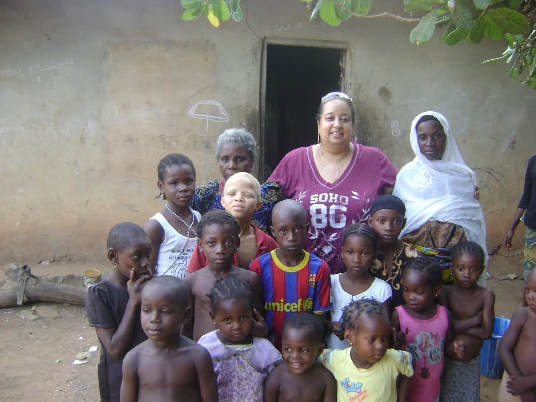 Group of children and adults smiling together.