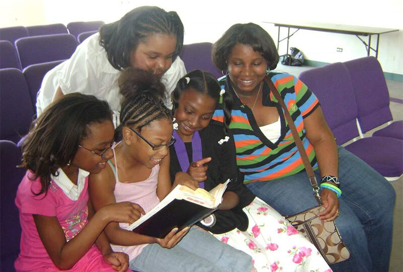 A group of people sitting around each other reading.